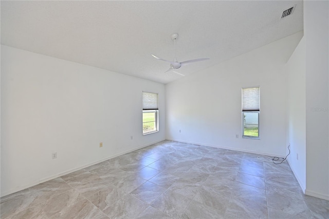 spare room featuring visible vents, baseboards, a ceiling fan, and vaulted ceiling