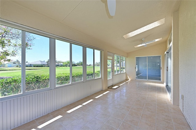 unfurnished sunroom with vaulted ceiling with skylight and ceiling fan