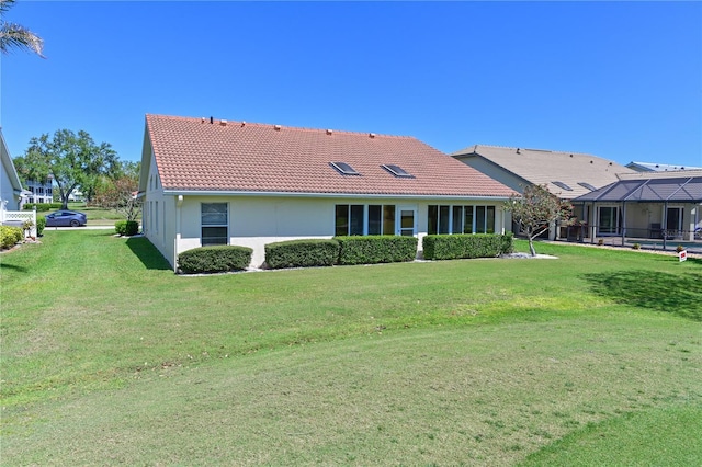 exterior space with stucco siding, a front lawn, and a tiled roof