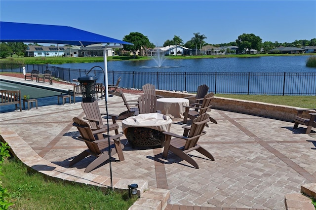 view of patio / terrace featuring a water view, an outdoor fire pit, and fence