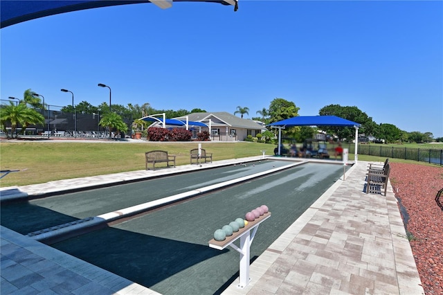view of community featuring a yard and fence