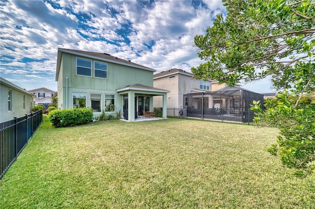 rear view of house with a lanai, a yard, a fenced backyard, and a patio area