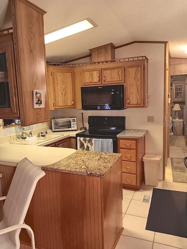 kitchen featuring black appliances, a sink, a peninsula, a toaster, and vaulted ceiling