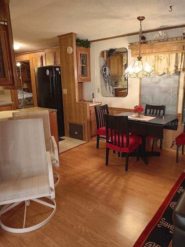 dining area with light wood-style flooring and a textured ceiling