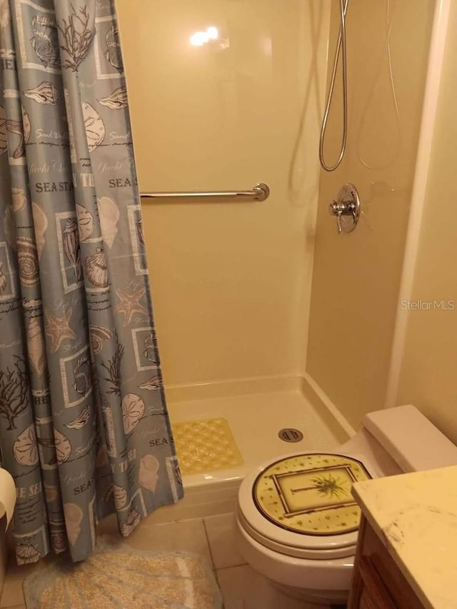 bathroom featuring toilet, a shower stall, and tile patterned flooring