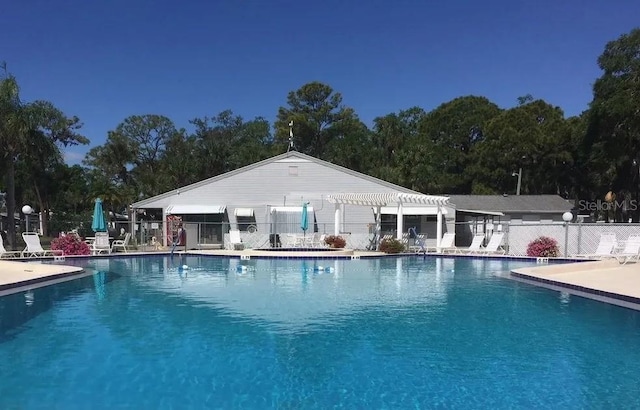 community pool featuring a patio area, fence, and a pergola