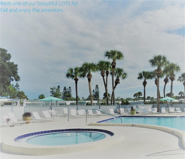 pool featuring a patio, a hot tub, and fence