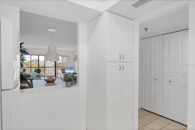 hall featuring light tile patterned flooring and visible vents