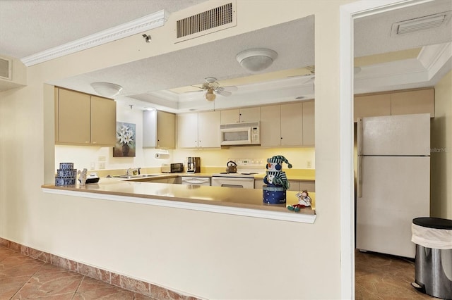 kitchen with visible vents, white appliances, a raised ceiling, and crown molding