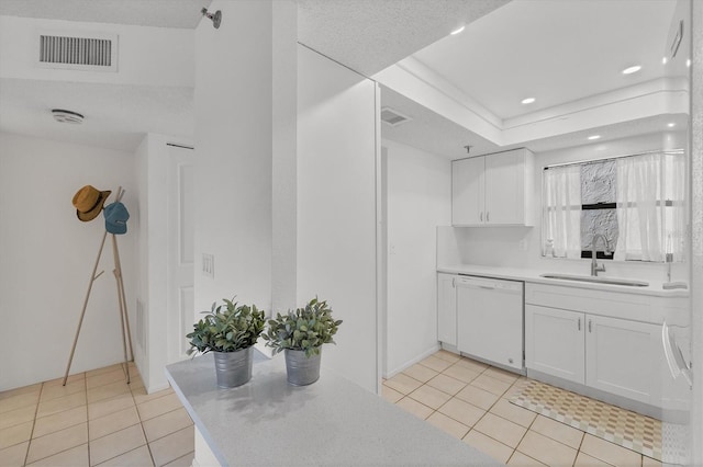 kitchen with light countertops, visible vents, white dishwasher, and a sink