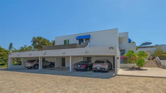 view of front facade featuring covered parking and stucco siding