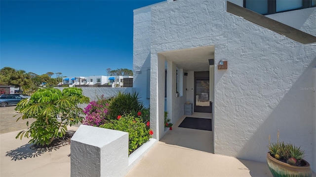 doorway to property featuring stucco siding