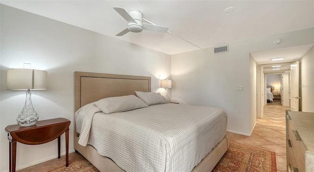 bedroom featuring light tile patterned floors, baseboards, visible vents, and ceiling fan