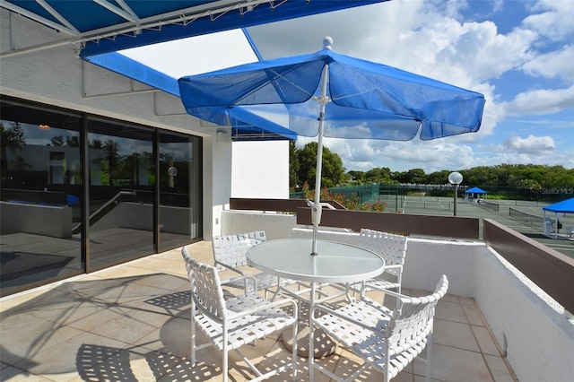 view of patio / terrace with a balcony and outdoor dining space