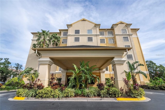 view of property featuring stucco siding and uncovered parking