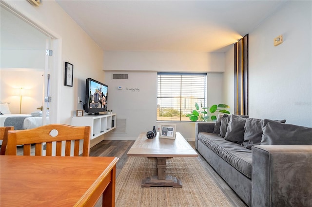 living area featuring wood finished floors, visible vents, and baseboards