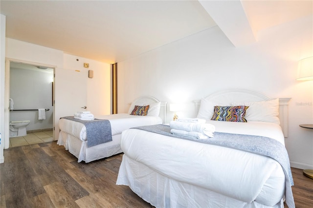 bedroom featuring ensuite bathroom and wood finished floors