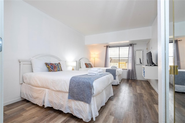 bedroom with baseboards and wood finished floors