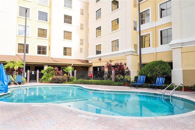 view of swimming pool featuring fence