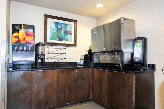 kitchen featuring dark brown cabinetry and dark stone counters