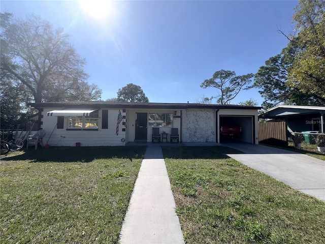 view of front facade with an attached garage, concrete driveway, and a front yard