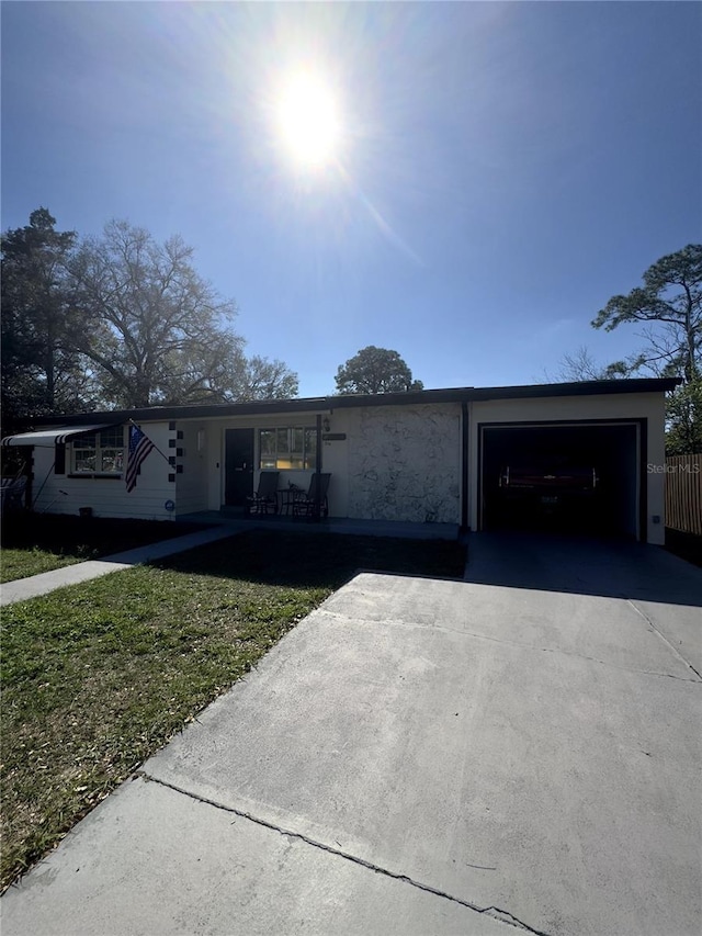 ranch-style home featuring aphalt driveway, a front yard, and an attached garage