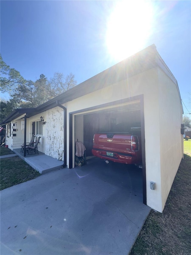 view of side of property with an attached garage and stucco siding