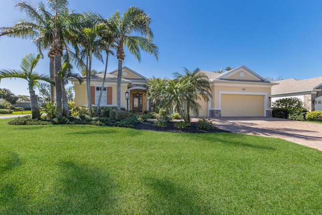 view of front of house with an attached garage, a front yard, stucco siding, stone siding, and driveway