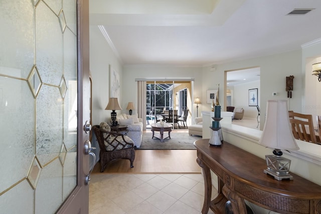 living area featuring light tile patterned floors, visible vents, and crown molding