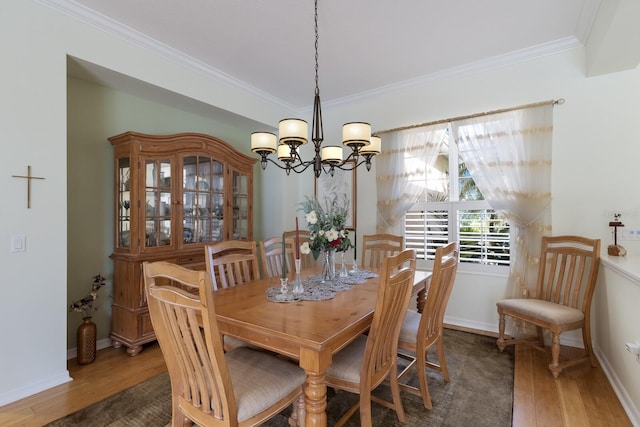 dining room with wood finished floors, baseboards, and ornamental molding