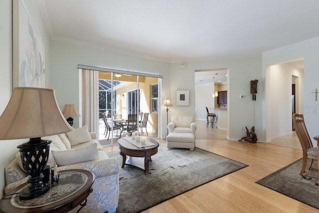 living room with baseboards, wood finished floors, and crown molding