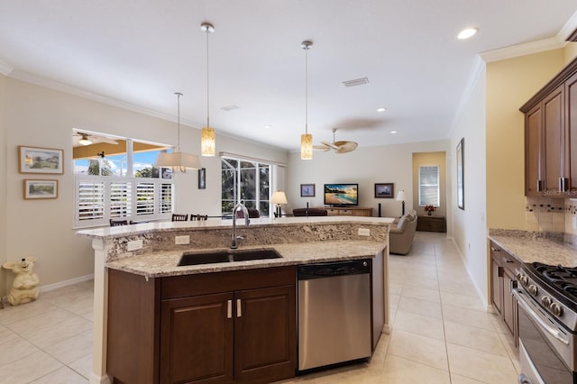 kitchen featuring open floor plan, ornamental molding, appliances with stainless steel finishes, and a sink