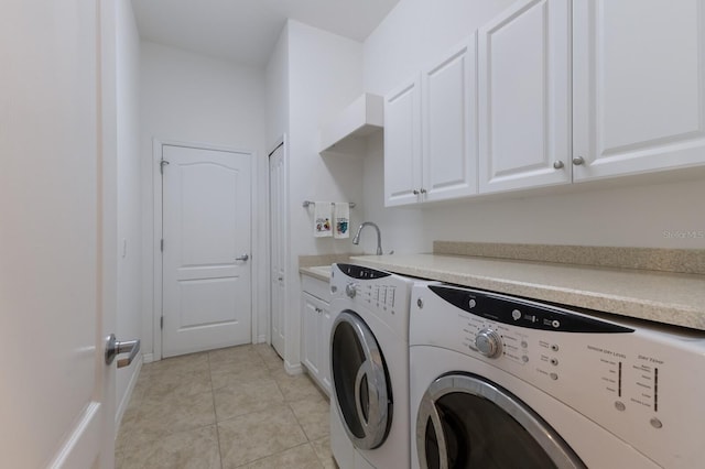 washroom featuring baseboards, light tile patterned flooring, cabinet space, separate washer and dryer, and a sink