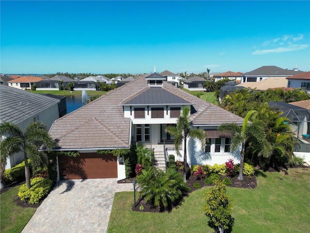 view of front of property with a residential view, a garage, decorative driveway, and a front yard