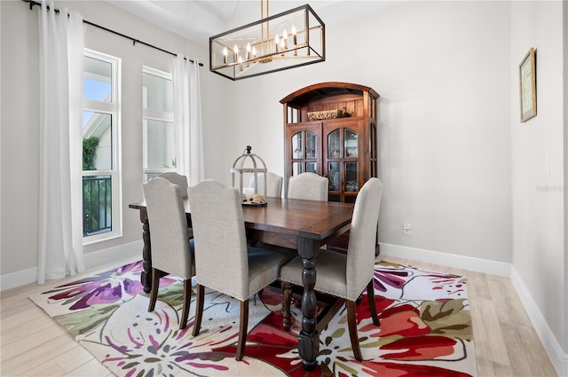 dining room featuring a chandelier, baseboards, and wood finished floors