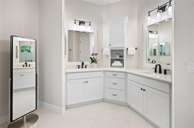 full bathroom with a sink, baseboards, two vanities, and tile patterned flooring