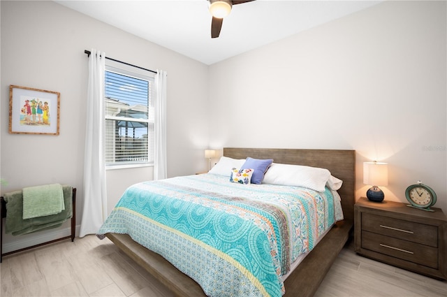 bedroom featuring baseboards, light wood-type flooring, and ceiling fan