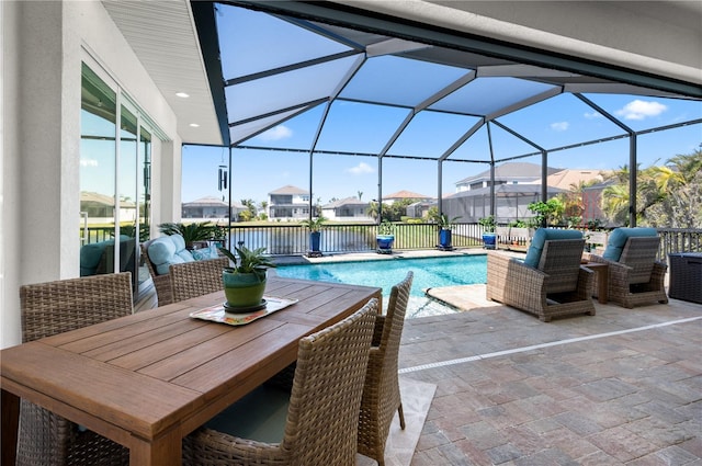 view of swimming pool with a fenced in pool, a residential view, glass enclosure, and a patio area