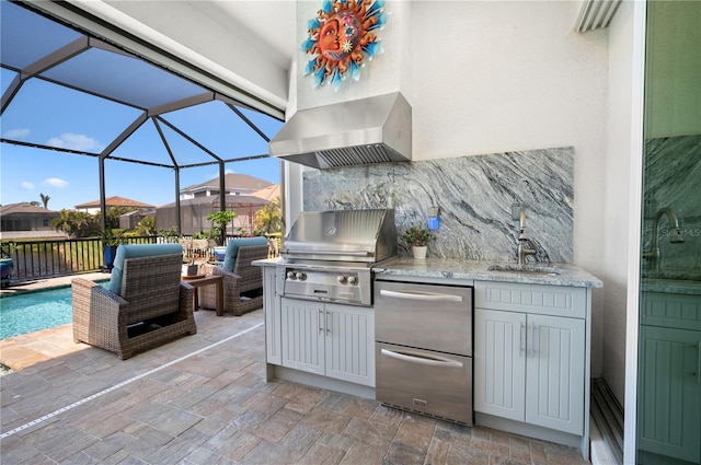 view of patio with a sink, glass enclosure, area for grilling, and an outdoor kitchen