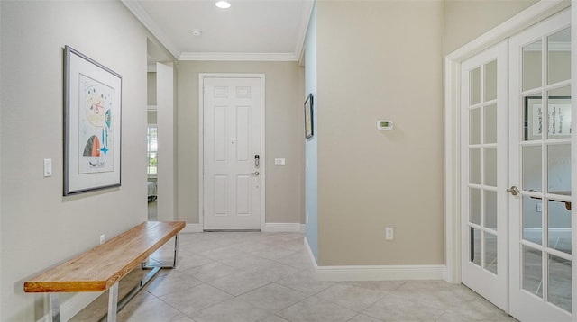 foyer entrance featuring light tile patterned floors, french doors, crown molding, and baseboards