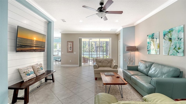 living area with crown molding, baseboards, ceiling fan, light tile patterned floors, and a textured ceiling