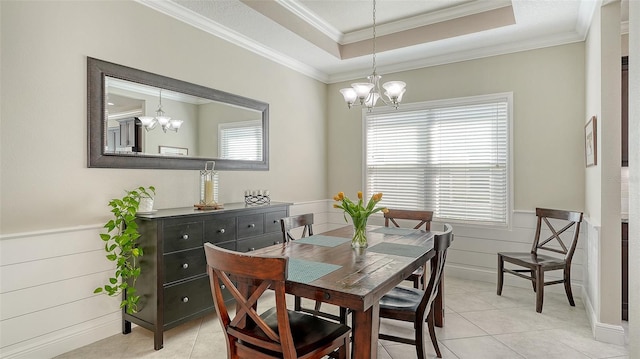 dining area with a notable chandelier, a healthy amount of sunlight, and a wainscoted wall