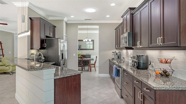 kitchen featuring stone countertops, ornamental molding, dark brown cabinetry, appliances with stainless steel finishes, and tasteful backsplash