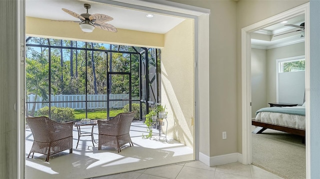 doorway with tile patterned flooring, crown molding, baseboards, and ceiling fan