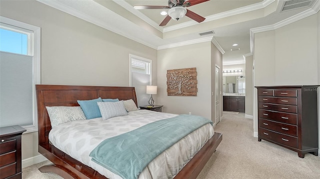 bedroom featuring visible vents, light carpet, a tray ceiling, crown molding, and baseboards