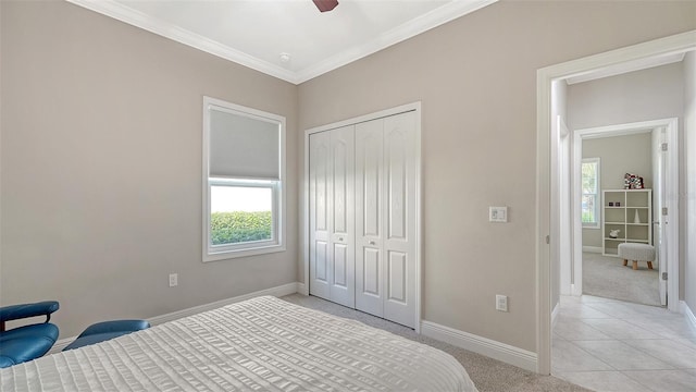 bedroom with a closet, multiple windows, crown molding, and baseboards