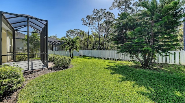 view of yard featuring glass enclosure and a fenced backyard