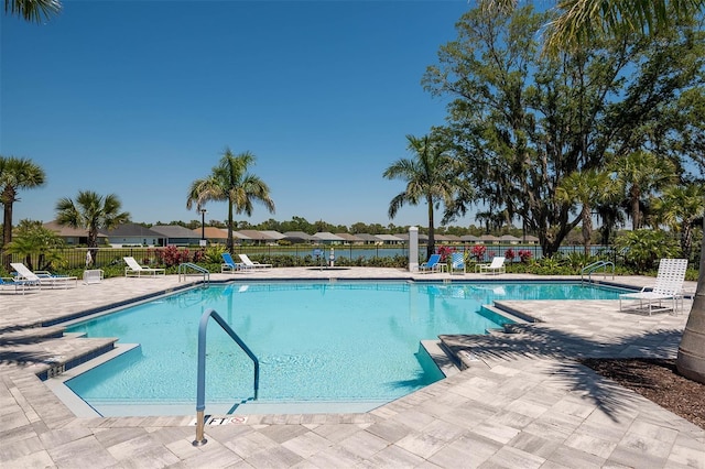 pool with a patio and fence