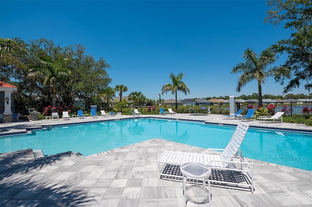 pool with a patio area and fence