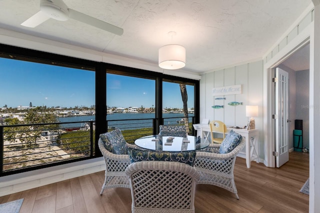 sunroom featuring a water view